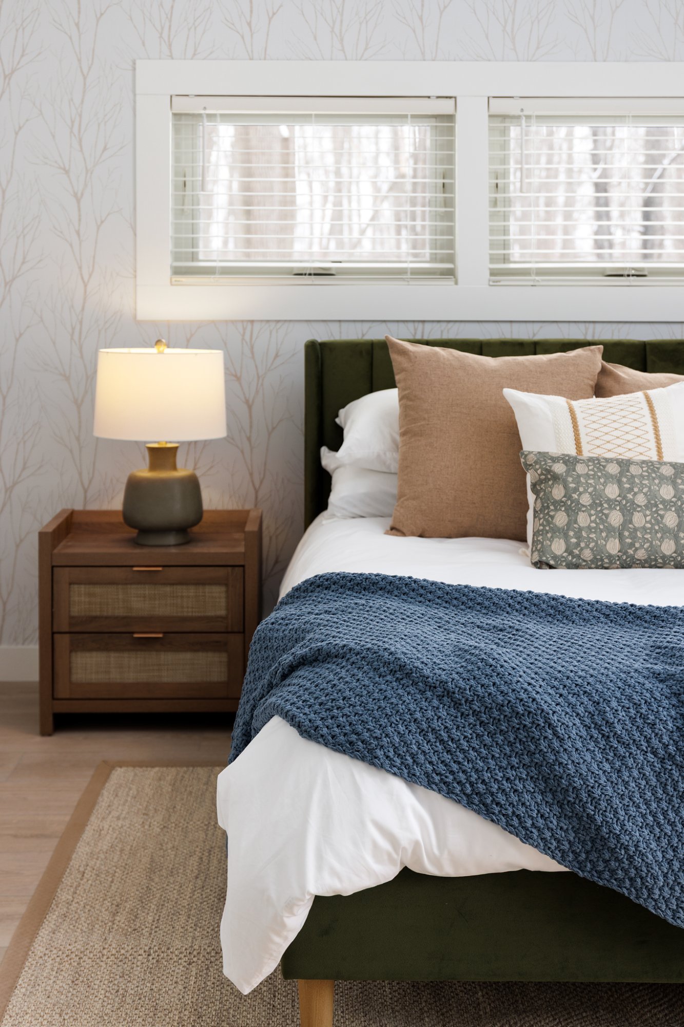 Bedroom with green headboard and birch wallpaper